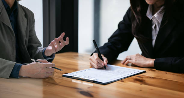 businessman and woman discussing and signing a contract in office. work nz